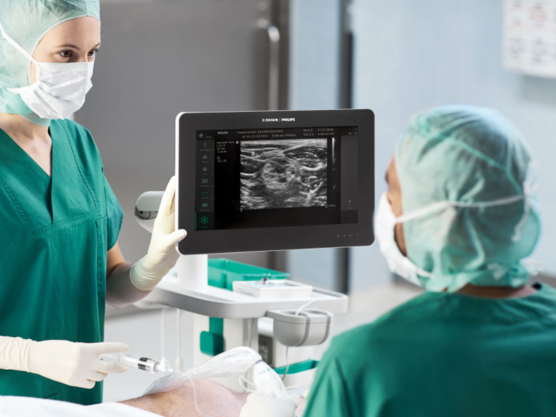 Two surgeons discuss a medical image on a monitor