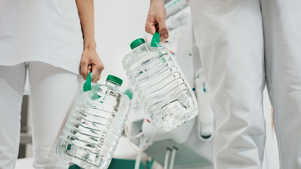 Two medical workers hold two bottles of Sol-Can