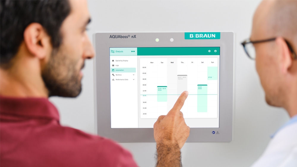 A technician touching the screen of the AQUAboss nX water treatment system.