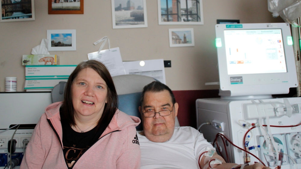 Claudia and Matthias Hatscher during home dialysis. Claudia sitting near by Matthias both looking straight to the camera.