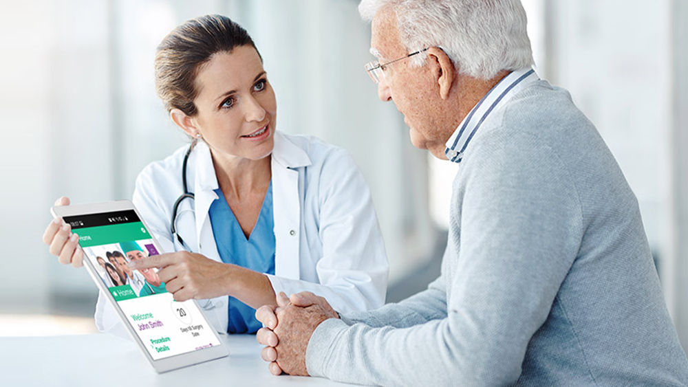 Female doctor explains the ForPatientApp on a tablet a patient