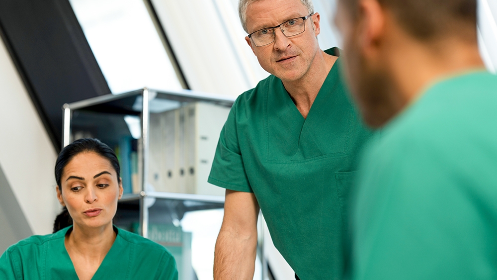 Three health care professionals consult each other