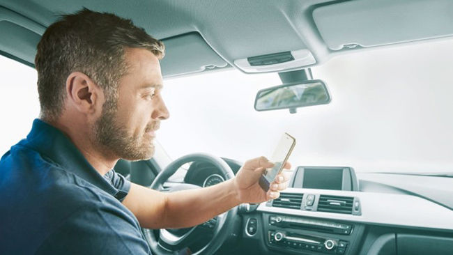 Man sitting in a car with his mobile device
