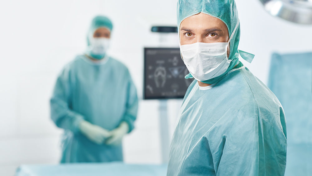 Two surgeons with OrthoPilot® Elite in the background