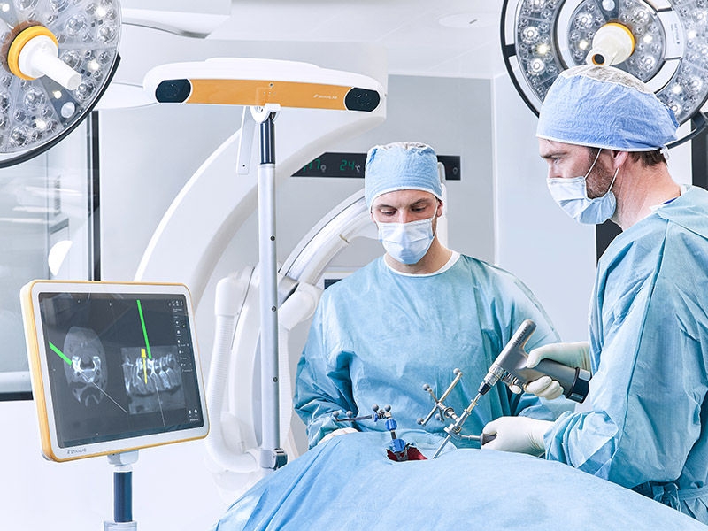 Two surgeons during a surgical procedure with Ennovate® Cervical MIS
