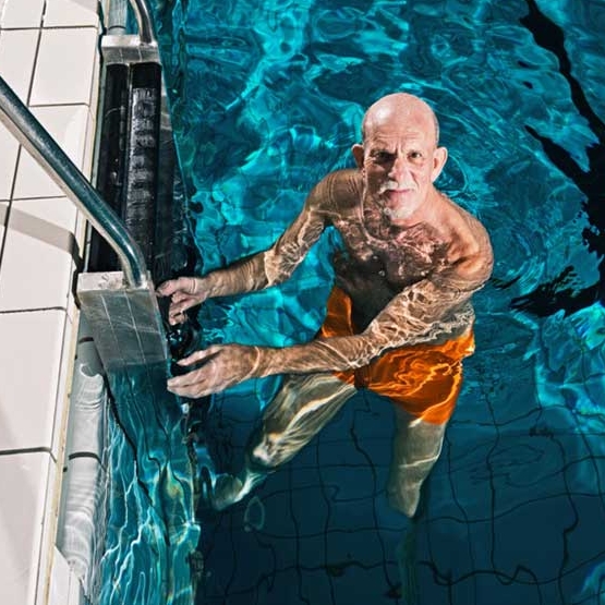 elderly man at ladder in swimming pool