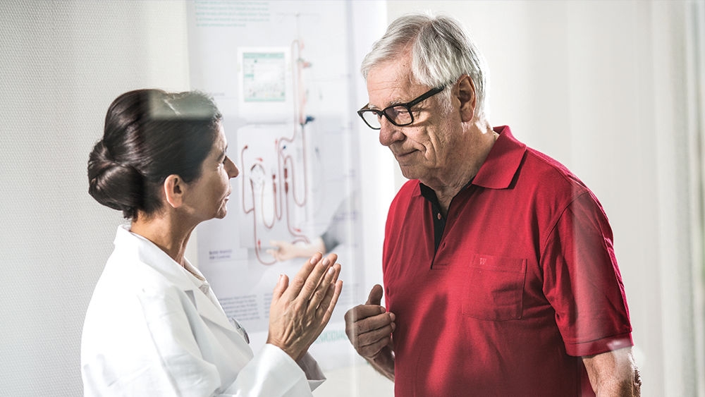 dialysis-kidney-transplant-elderly-man-red-shirt-talking-to-professional-landscape