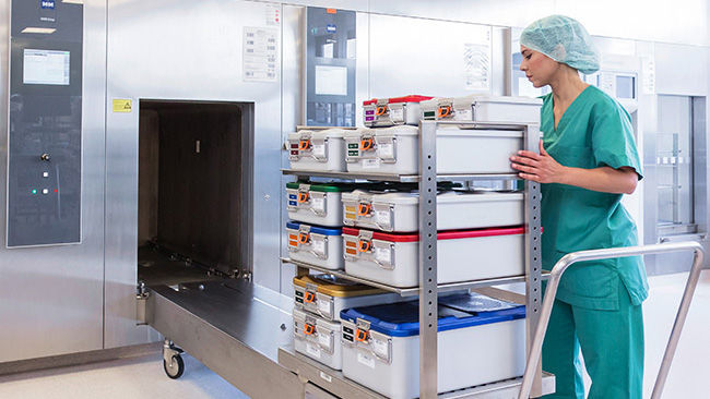 Female employee in the central sterile supply department with containers