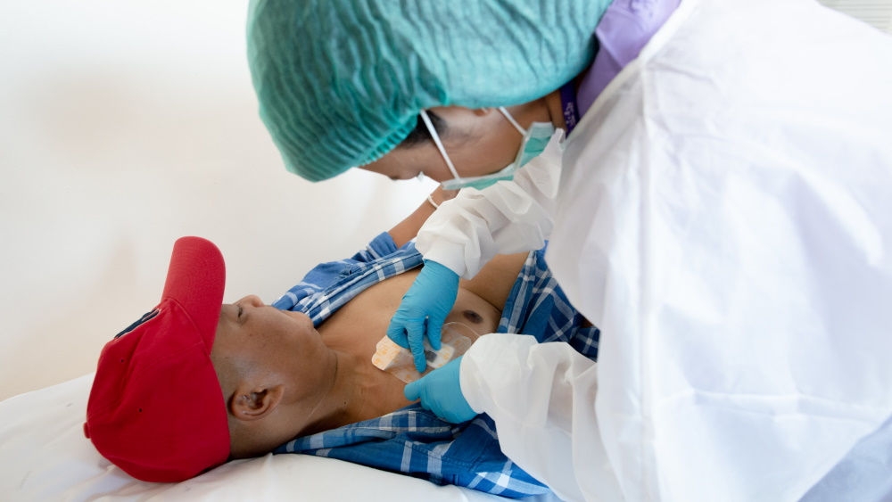 nurse who treats his patient who wears a red cap