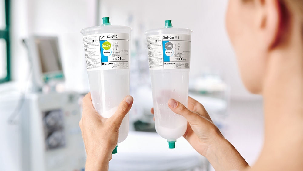 Dialysis nurse comparing two bicarbonate cartridges, Sol-Cart B, with different fill volumes and residuals after treatment.