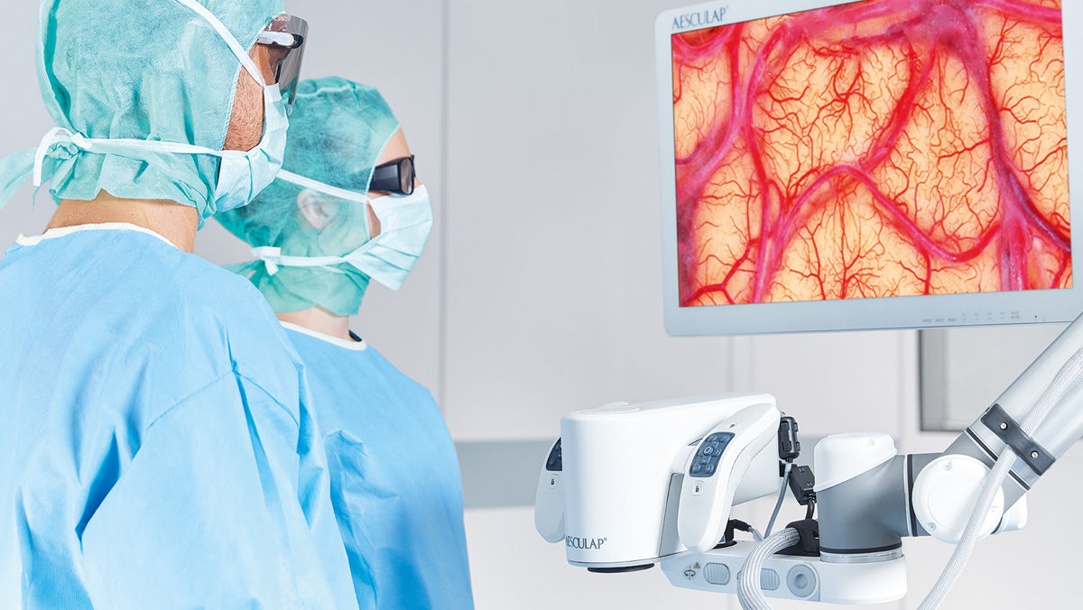 A surgeons in the operating room using the Aesculap Aeos® digital surgical microscope platform