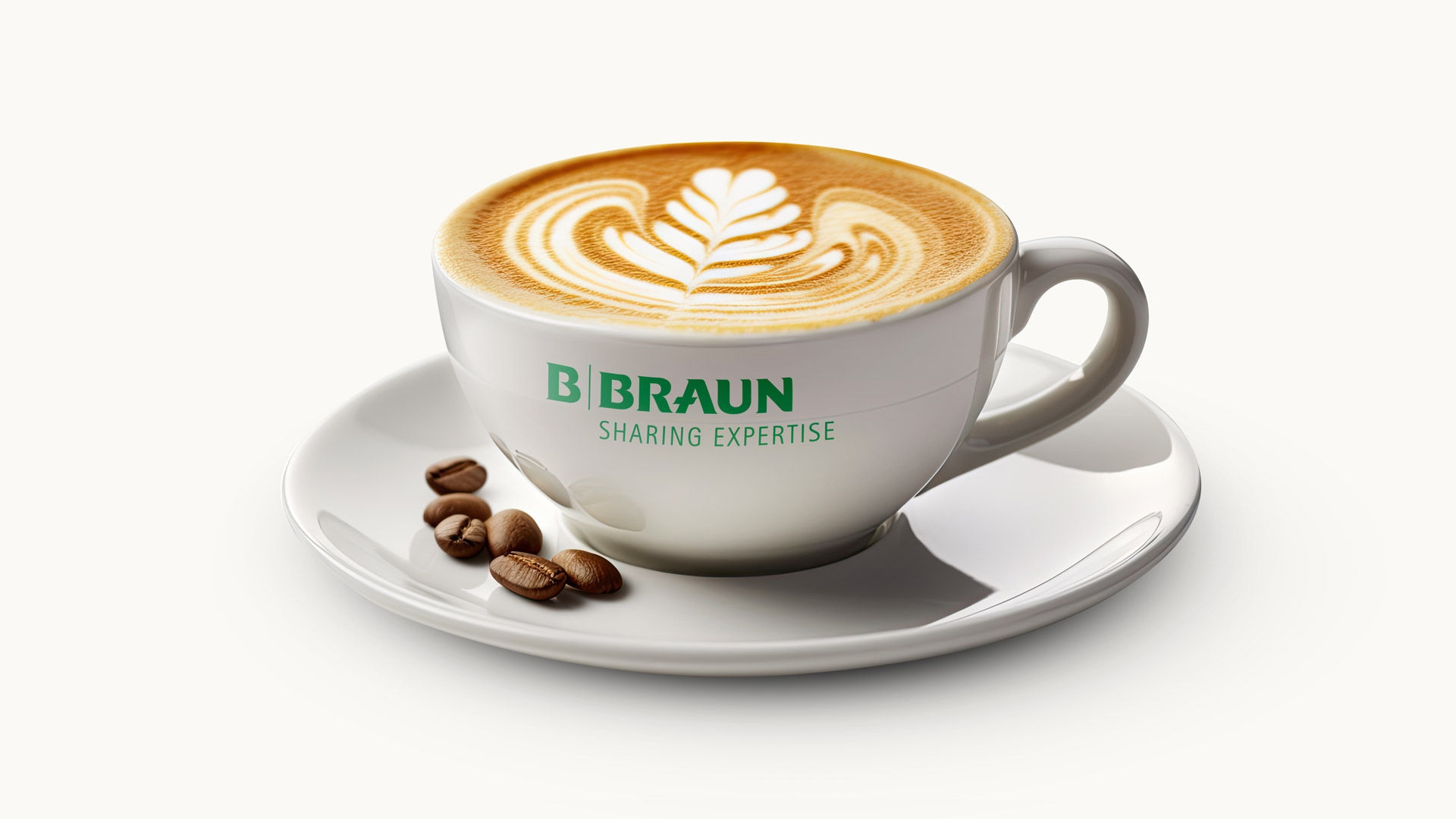 White coffee cup with leaf-shaped latte art and B. Braun logo on saucer with coffee beans.
