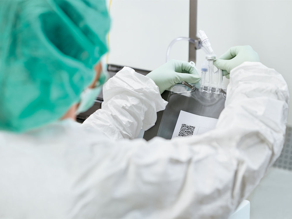 health care worker is preparing  medications at a compounding device