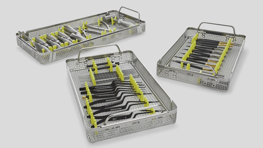Three stainless steel trays containing neatly arranged surgical instruments with yellow silicone holders, designed for sterilization and safe handling in medical environments.
