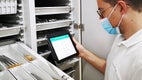 Alex Fernandez in front of a surgical instruments trolley with the BSM app on his tablet