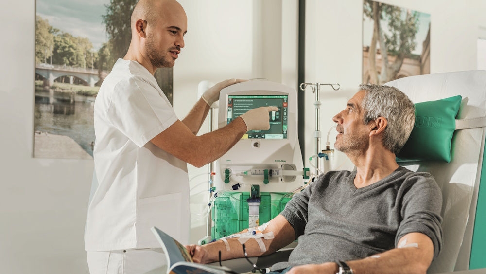 Healthcare professional explaining blood purification therapy to a patient using the OMNI platform
