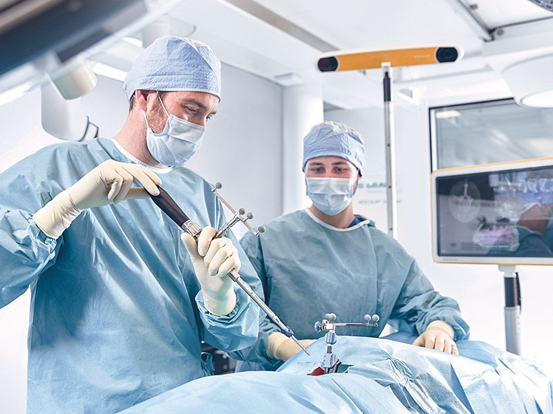 Two surgeons during a surgical procedure with Ennovate® TLSP drill guide
