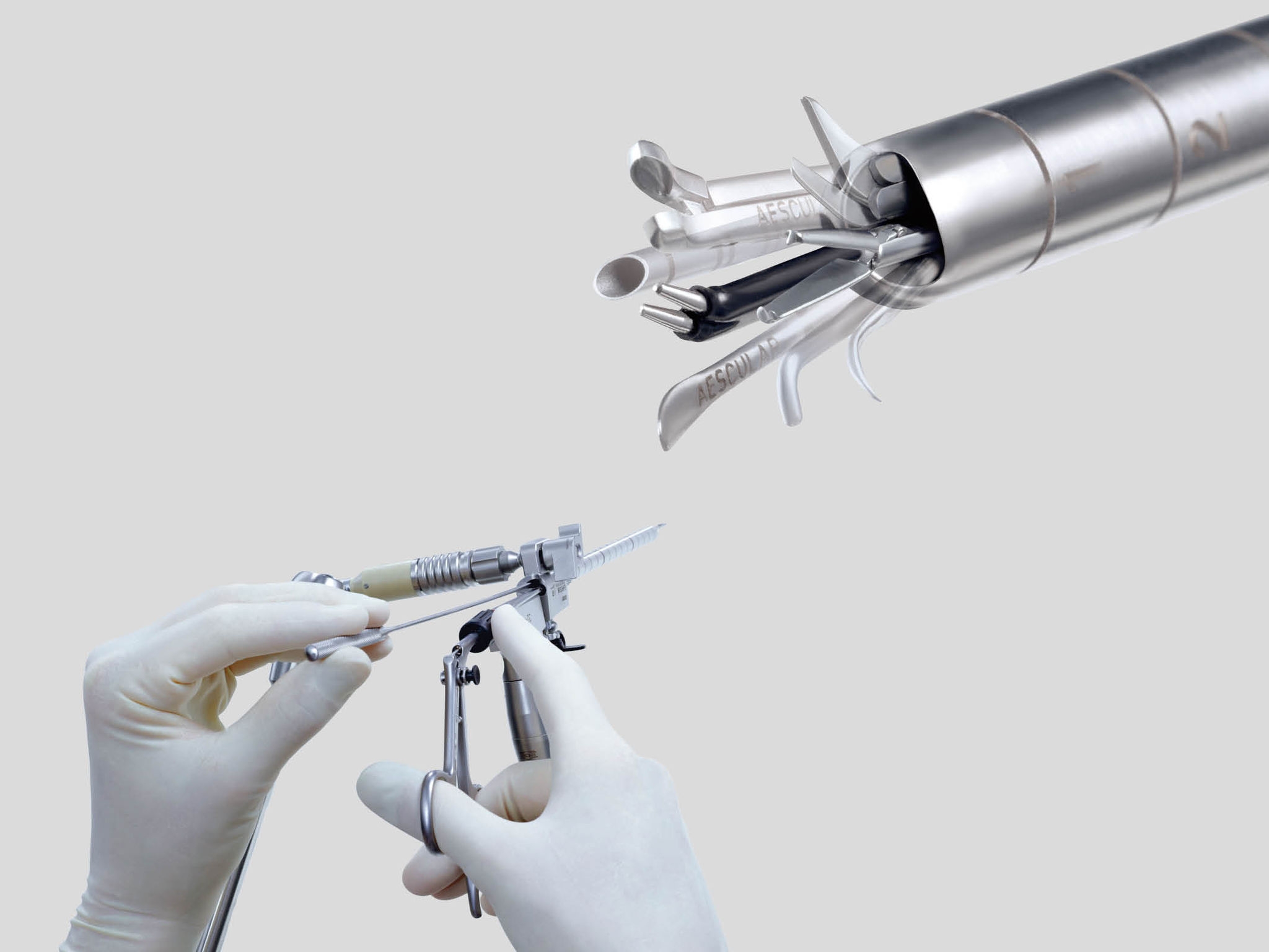 Close-up of gloved hands adjusting the Minop InVent surgical instrument with a detailed view of the instrument's attachments