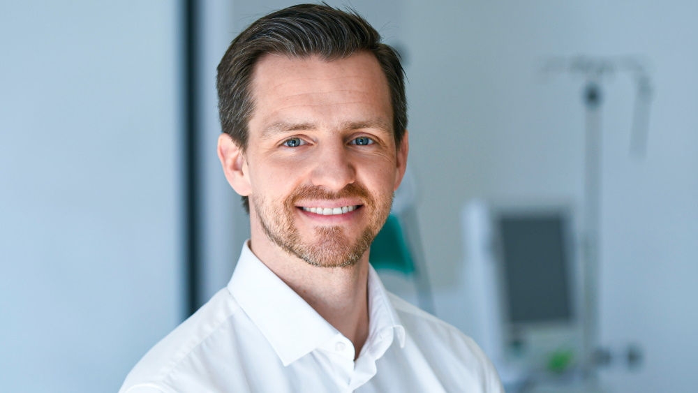 A potrait of Benjamin Olson. He is smiling in the camera.
