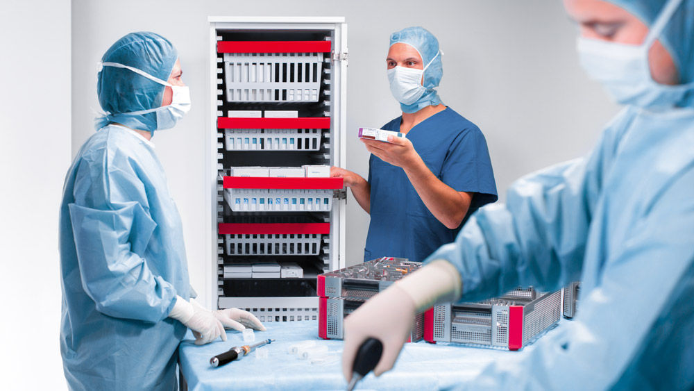 Three surgeons prepairs the instruments for a surgcial procedure