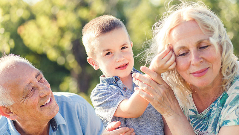 Grandparents with grandson enjoying time toghether in park