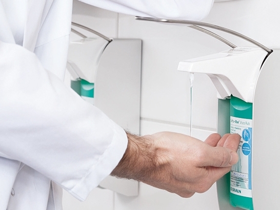 Male HCP hand using hand hygiene dispenser