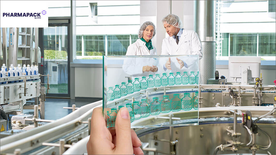 Two production workers in lab coats are discussing
