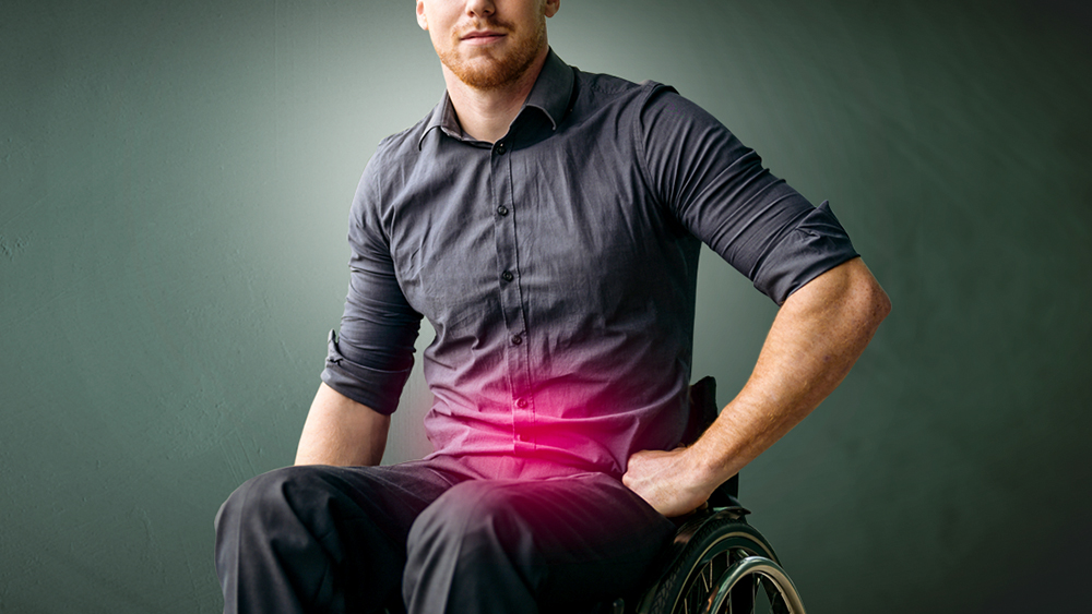 Man sitting in a wheelchair, red spot on abdomen indicates pain in the urinary tract