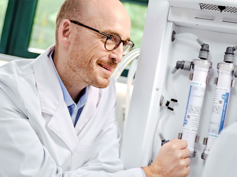 Nephrologist and dialysis nurse review fluid filters (Diacap Ultra Pro) at the back of a dialysis machine Dialog iQ.