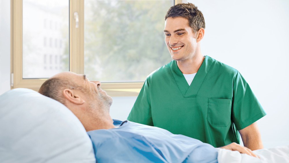 Nurse and patient in a hospital room both smiling
