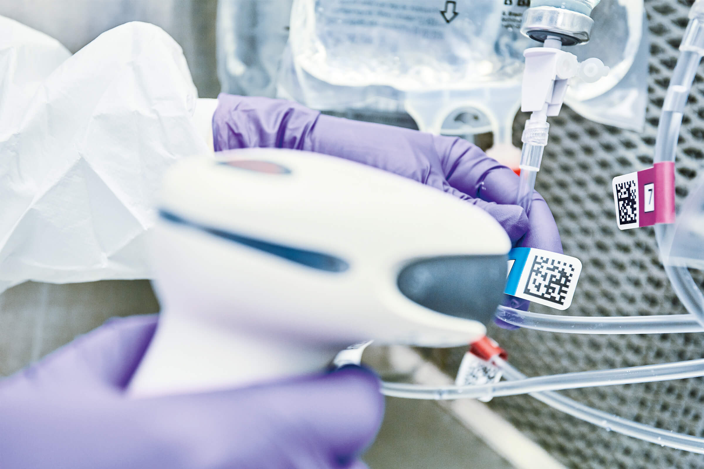 Hands of a medical worker scanning a QR code on compounding device