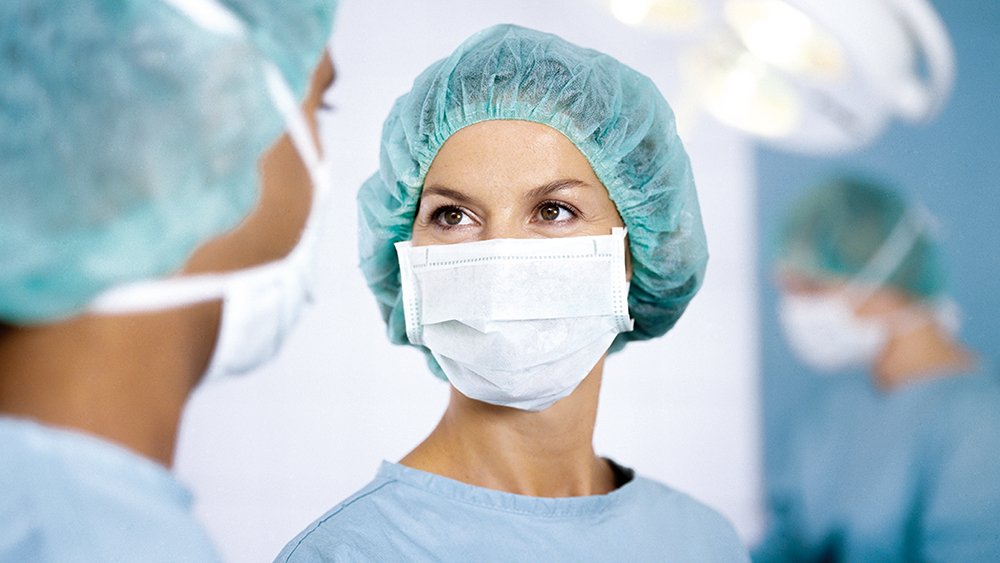 Two surgeons with face masks and caps