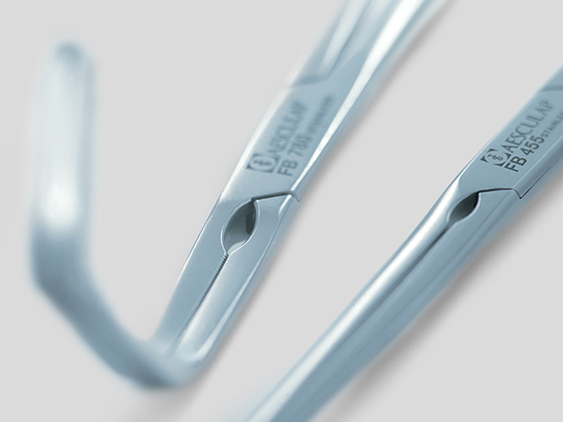 Surgical instruments with the Aesculap logo, laid out on a table
