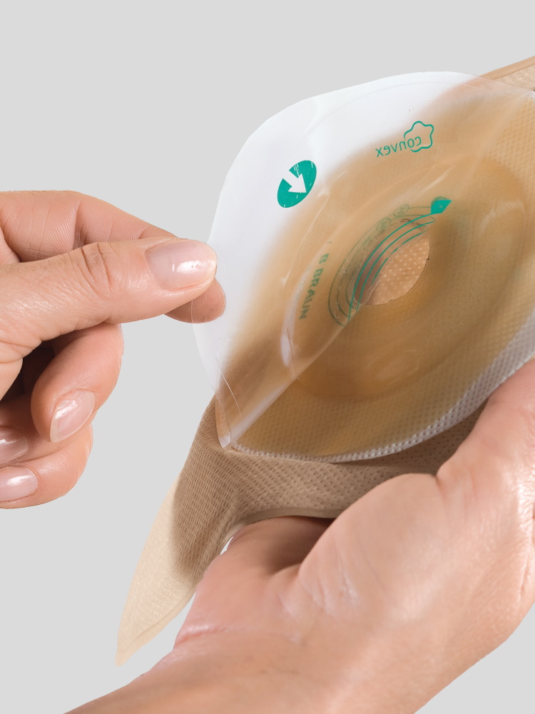 Two hands holding a stoma bag with a convex shaped wafer