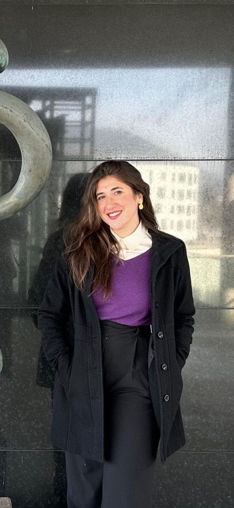 Woman wearing a black coat and a purple sweater