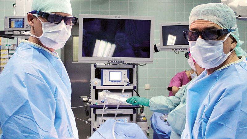 The urologist Dr. med. Michael Ludwig (left) and Dr. med. Bernd Heinzmann (right) with the special glasses for 3D vision – together at the operating table.