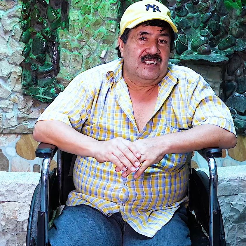 Man from Ecuador with cap who sits in a wheelchair